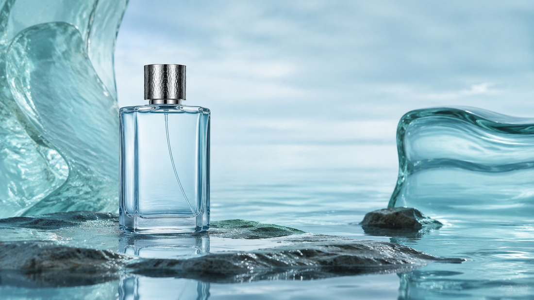 Aquatic perfume bottle surrounded by water, wet stone and sea-glass forms